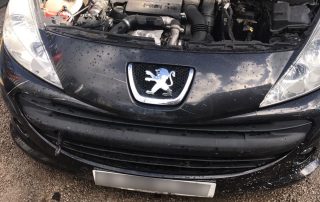 Black Peugeot scrap car with bonnet open